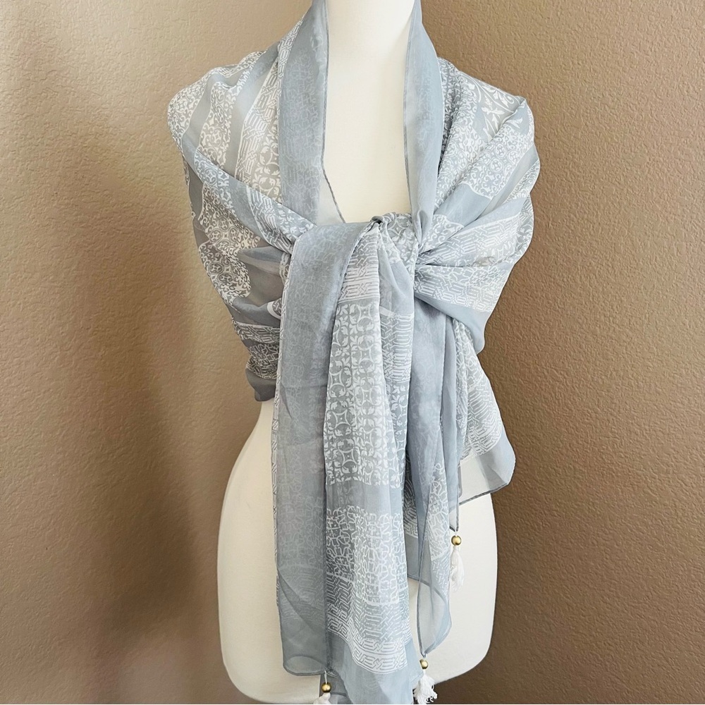 27”x72” light gray scarf /shawl with a white pattern.